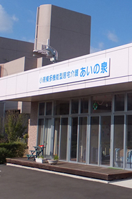 介護施設の建物外観。モダンな低層建築で、入口上部に施設名看板がある
